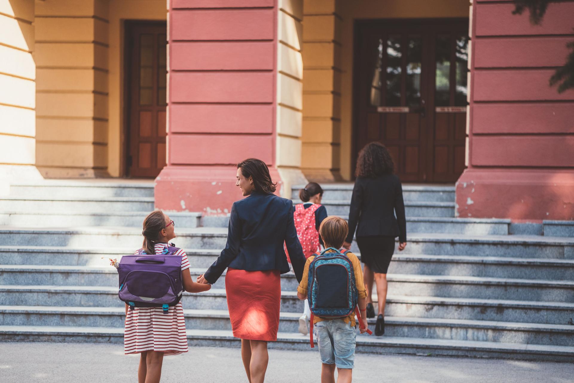 Mother leads her children to school
